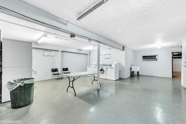 finished basement featuring separate washer and dryer and a sink