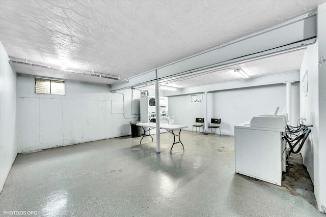 below grade area featuring stacked washer / dryer, washing machine and clothes dryer, and a textured ceiling
