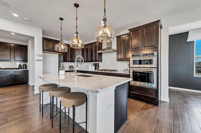 1995 Norwich Ln, Bolingbrook, IL 60490 - kitchen with a sink, wall chimney range hood, appliances with stainless steel finishes, light stone counters, and dark wood finished floors