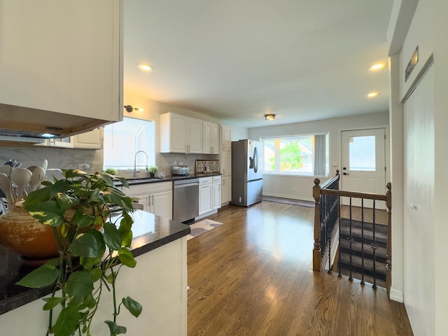 8024 N Odell Ave, Niles, IL 60714 - kitchen with appliances with stainless steel finishes, dark countertops, white cabinets, backsplash, and dark wood-type flooring