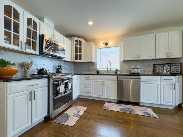 8024 N Odell Ave, Niles, IL 60714 - kitchen with appliances with stainless steel finishes, a sink, dark countertops, backsplash, and recessed lighting