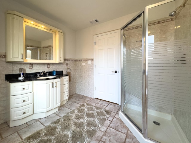 8024 N Odell Ave, Niles, IL 60714 - bathroom featuring tile walls, a shower stall, vanity, stone tile floors, and wainscoting