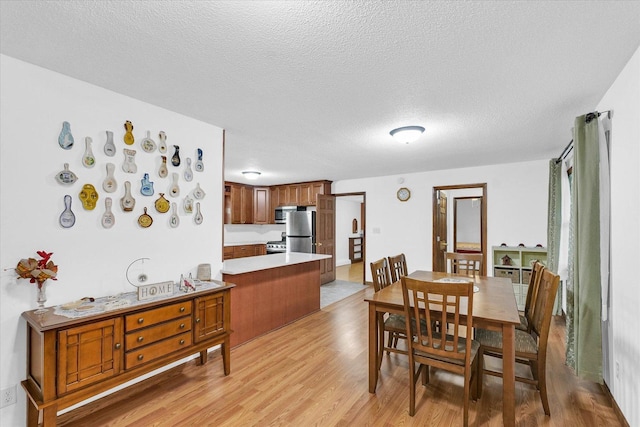 2908 Rolling Acres Dr, Champaign, IL 61822 - dining area featuring light wood-style flooring and a textured ceiling