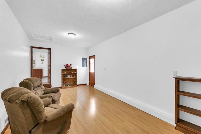 2908 Rolling Acres Dr, Champaign, IL 61822 - living room with light wood-type flooring, a textured ceiling, and attic access