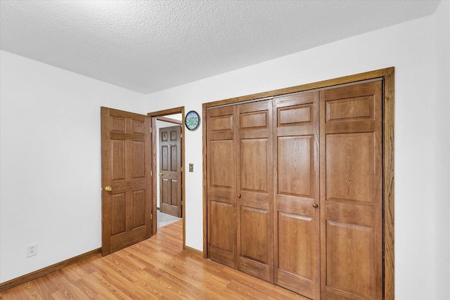 2908 Rolling Acres Dr, Champaign, IL 61822 - unfurnished bedroom featuring light wood-style floors, a textured ceiling, and a closet