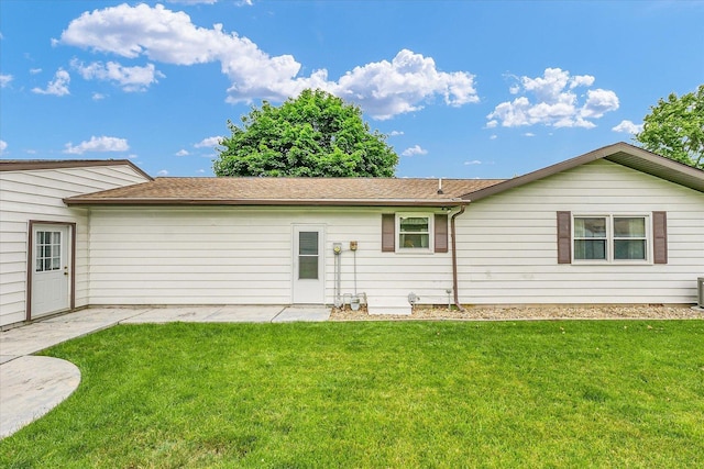 2908 Rolling Acres Dr, Champaign, IL 61822 - rear view of house featuring a lawn, a shingled roof, and a patio