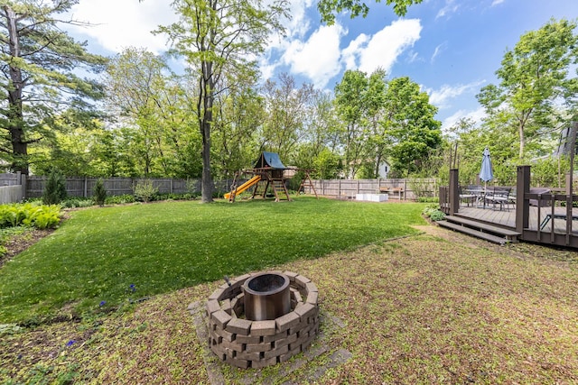 1613 Swallow St, Naperville, IL 60565 - view of yard with a fire pit, a playground, a deck, and view of wooded area