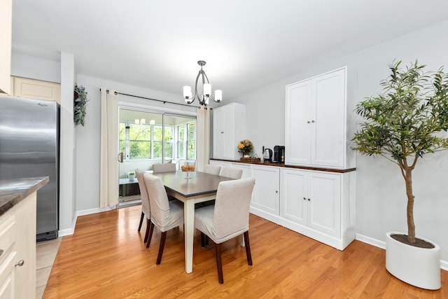 1613 Swallow St, Naperville, IL 60565 - dining area with light wood finished floors, a chandelier, and baseboards