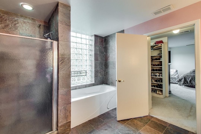 full bath with a stall shower, a bath, and a walk in closet