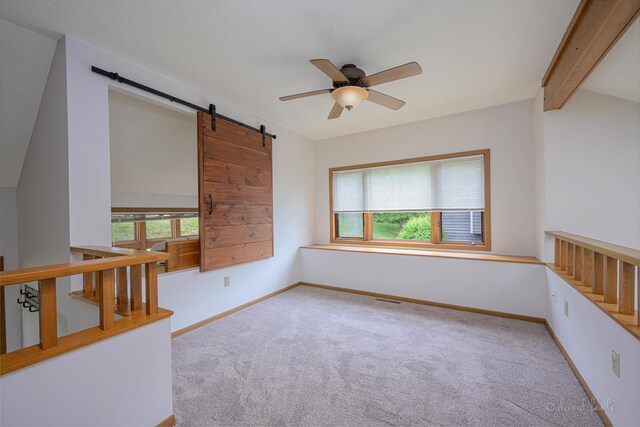 22 Valleywood Ln Unit 22, Galena, IL 61036 - spare room with carpet flooring, ceiling fan, a barn door, and baseboards