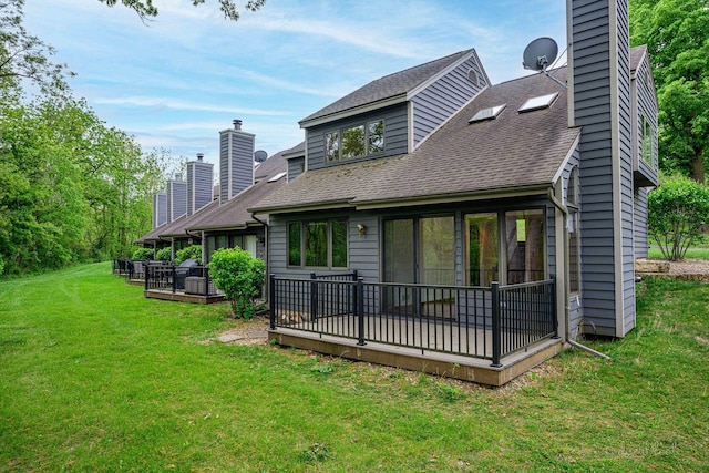 22 Valleywood Ln Unit 22, Galena, IL 61036 - back of property featuring a chimney, a wooden deck, a shingled roof, and a yard