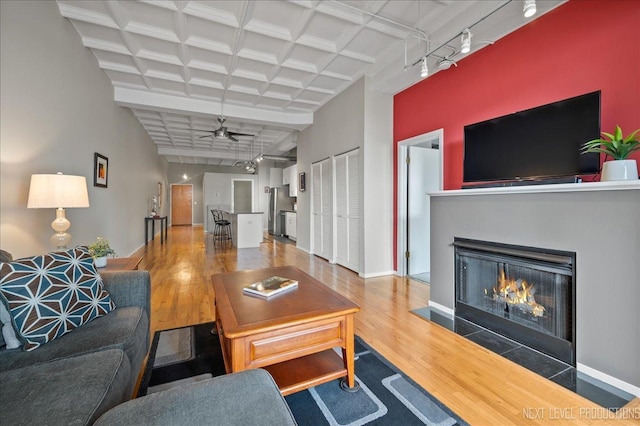 1307 S Wabash Ave Unit 402, Chicago, IL 60605 - living area featuring wood finished floors, a ceiling fan, a lit fireplace, beamed ceiling, and baseboards