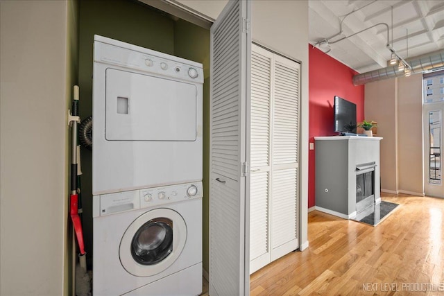 1307 S Wabash Ave Unit 402, Chicago, IL 60605 - laundry room with estacked washer and dryer, wood finished floors, and a multi sided fireplace
