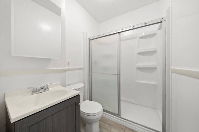 full bath featuring a shower stall, toilet, vanity, and wood finished floors