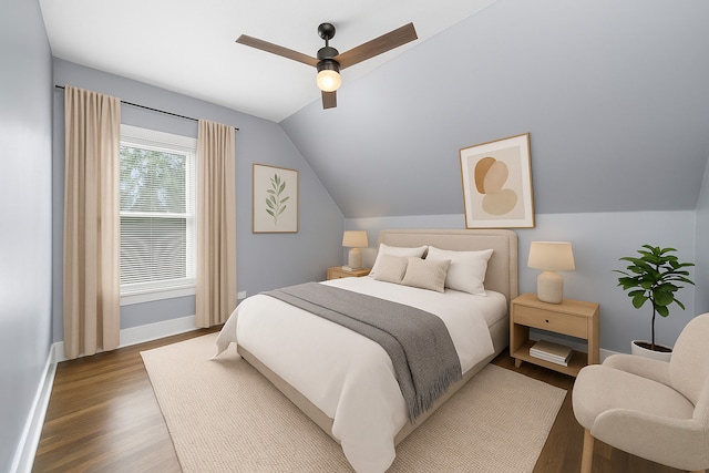 bedroom featuring wood finished floors, lofted ceiling, baseboards, and ceiling fan