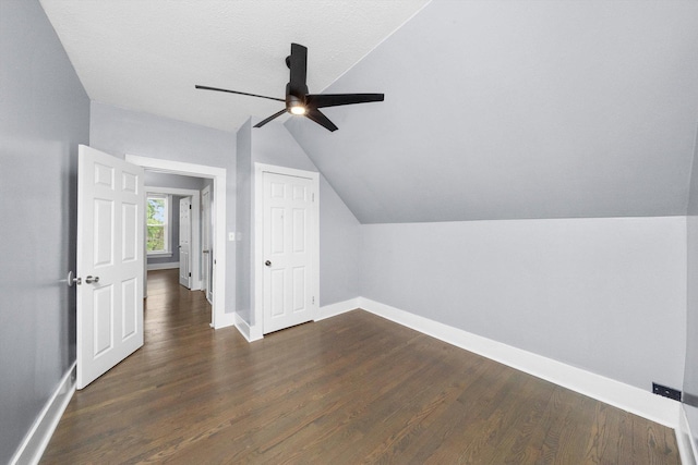 additional living space featuring ceiling fan, lofted ceiling, baseboards, and dark wood-type flooring