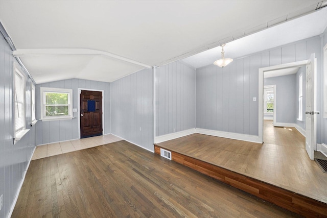 entrance foyer featuring hardwood / wood-style flooring, vaulted ceiling, and healthy amount of natural light