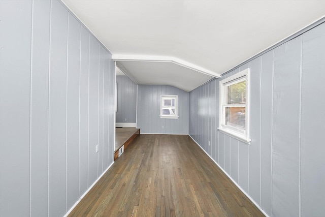 hallway featuring wood finished floors and lofted ceiling