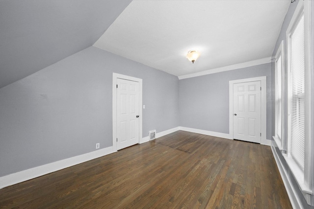 bonus room with dark wood-style floors, baseboards, and vaulted ceiling