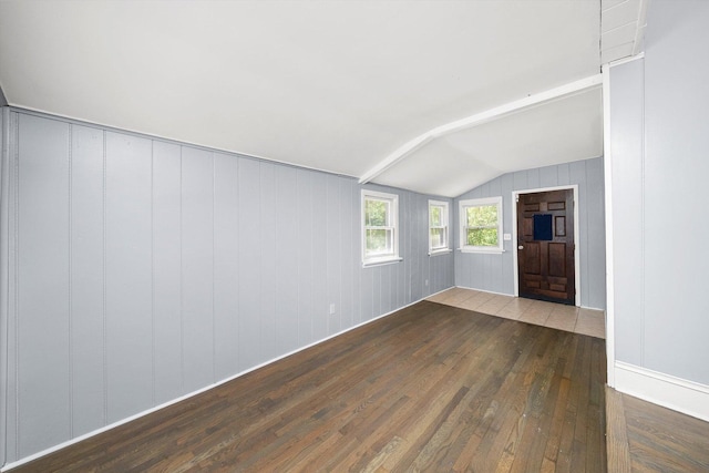 spare room featuring wood-type flooring and vaulted ceiling