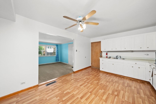 17714 Dogwood Ln, Hazel Crest, IL 60429 - kitchen with ceiling fan, light wood-type flooring, a sink, baseboards, and white cabinets