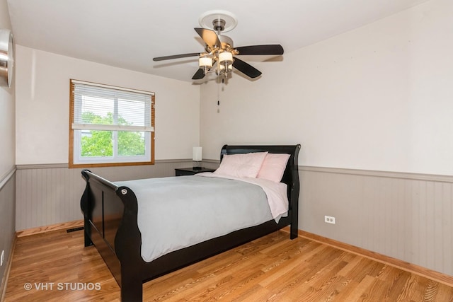 3724 Monitor Dr, Hanover Park, IL 60133 - bedroom featuring wainscoting, light wood-style flooring, ceiling fan, and wooden walls