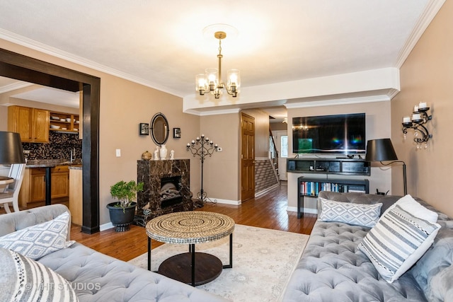 3724 Monitor Dr, Hanover Park, IL 60133 - living room featuring wood finished floors, a chandelier, ornamental molding, a premium fireplace, and baseboards