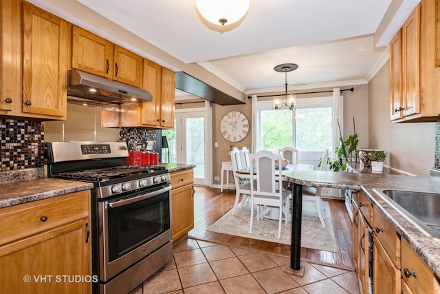 3724 Monitor Dr, Hanover Park, IL 60133 - kitchen with under cabinet range hood, stainless steel range with gas stovetop, backsplash, ornamental molding, and light tile patterned floors