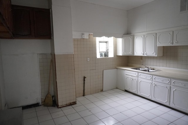 7225 S Princeton Ave, Chicago, IL 60621 - kitchen featuring a sink, tile walls, light tile patterned floors, light countertops, and white cabinetry