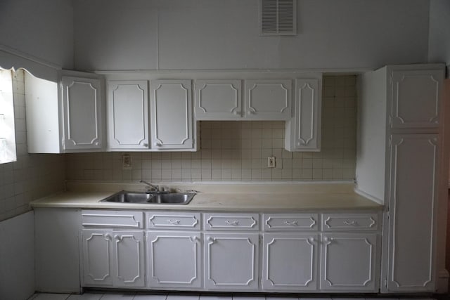 7225 S Princeton Ave, Chicago, IL 60621 - kitchen featuring a sink, light countertops, white cabinets, and decorative backsplash