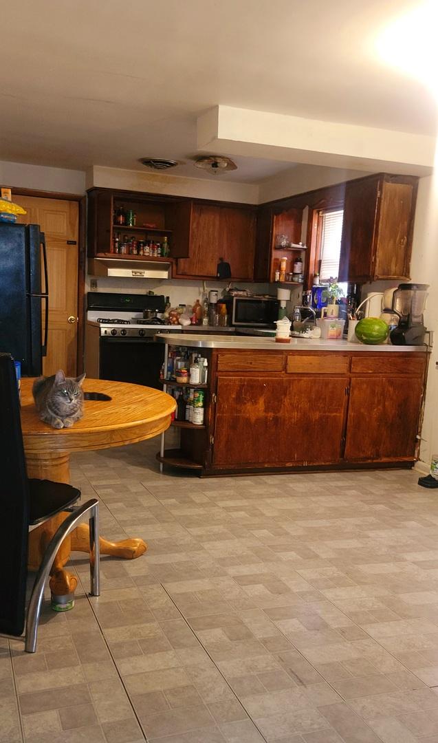 3355 W 65th St, Chicago, IL 60629 - kitchen with open shelves, freestanding refrigerator, and light countertops