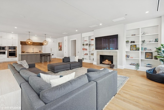 1109 W Washington Blvd Unit 2B, Chicago, IL 60607 - living area featuring built in features, a premium fireplace, light wood finished floors, and recessed lighting