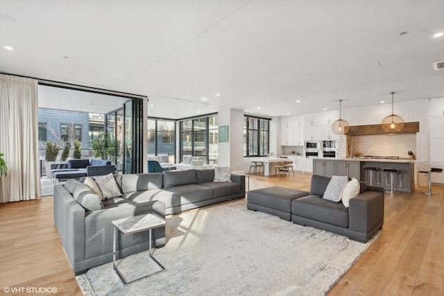 1109 W Washington Blvd Unit 2B, Chicago, IL 60607 - living room featuring light wood finished floors, a wall of windows, and recessed lighting