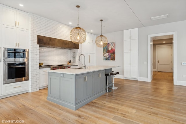 1109 W Washington Blvd Unit 2B, Chicago, IL 60607 - kitchen with a sink, gray cabinets, white cabinets, backsplash, and light wood-style floors