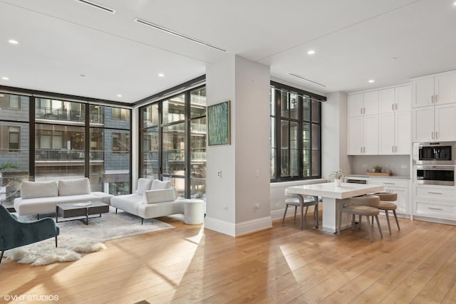 1109 W Washington Blvd Unit 2B, Chicago, IL 60607 - living room with light wood-style floors, baseboards, a wall of windows, and recessed lighting