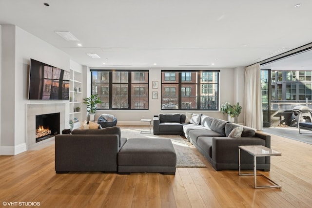 1109 W Washington Blvd Unit 2B, Chicago, IL 60607 - living area with light wood finished floors, built in shelves, a warm lit fireplace, baseboards, and recessed lighting
