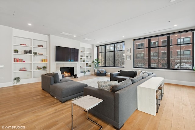 1109 W Washington Blvd Unit 2B, Chicago, IL 60607 - living area featuring baseboards, built in features, light wood-type flooring, a lit fireplace, and recessed lighting
