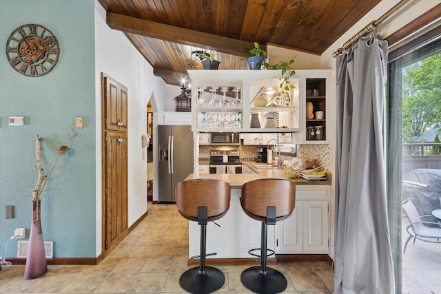 608 E Webster St, Polo, IL 61064 - kitchen with stainless steel appliances, wood ceiling, tasteful backsplash, white cabinets, and a peninsula