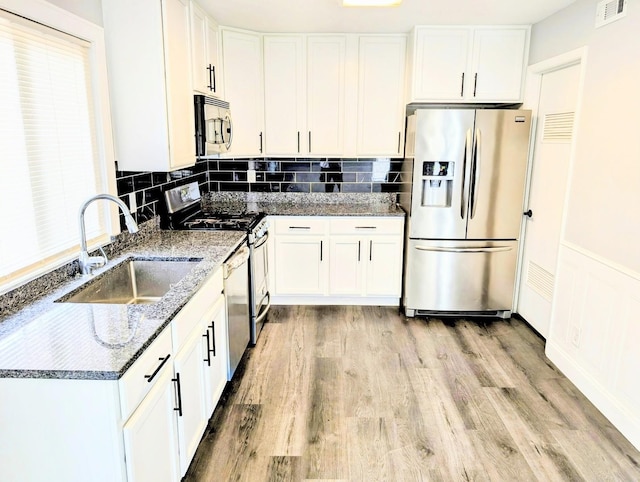 410 Wildwood Ct Unit 410, Romeoville, IL 60446 - kitchen featuring stainless steel appliances, a sink, white cabinets, and a wainscoted wall
