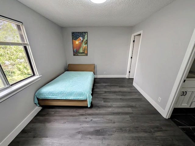 410 Wildwood Ct Unit 410, Romeoville, IL 60446 - bedroom with multiple windows, a textured ceiling, dark wood-style floors, and baseboards
