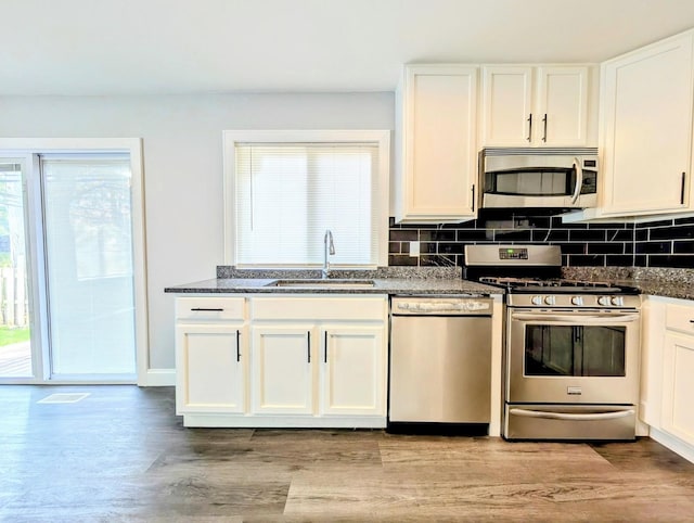 410 Wildwood Ct Unit 410, Romeoville, IL 60446 - kitchen with stainless steel appliances, a sink, healthy amount of natural light, and dark stone counters