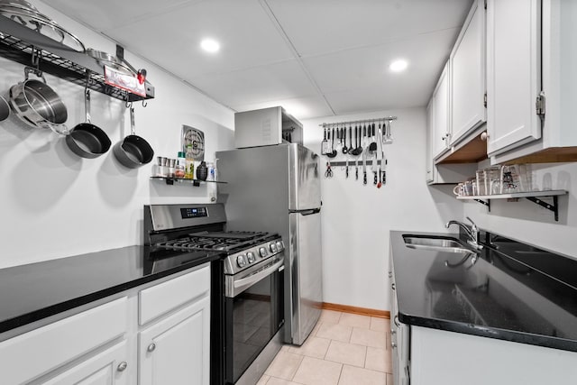 5855 W Higgins Ave Unit Gr, Chicago, IL 60630 - kitchen featuring stainless steel gas range, a sink, white cabinets, dark countertops, and a drop ceiling