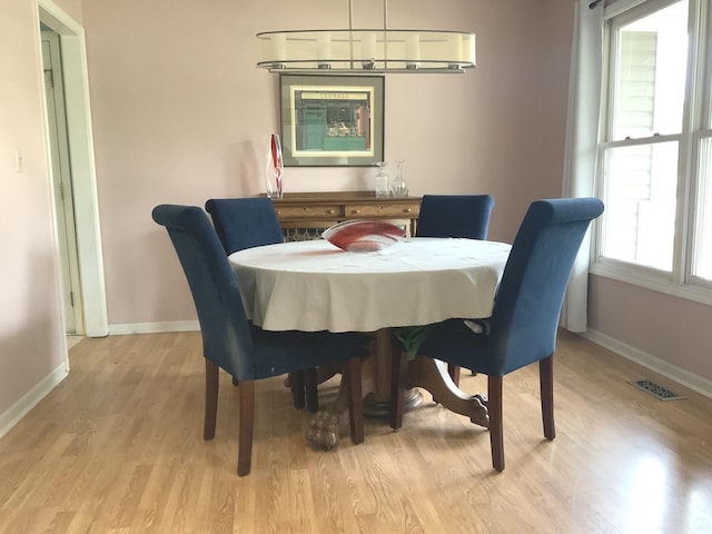 dining area with light wood-style flooring and baseboards