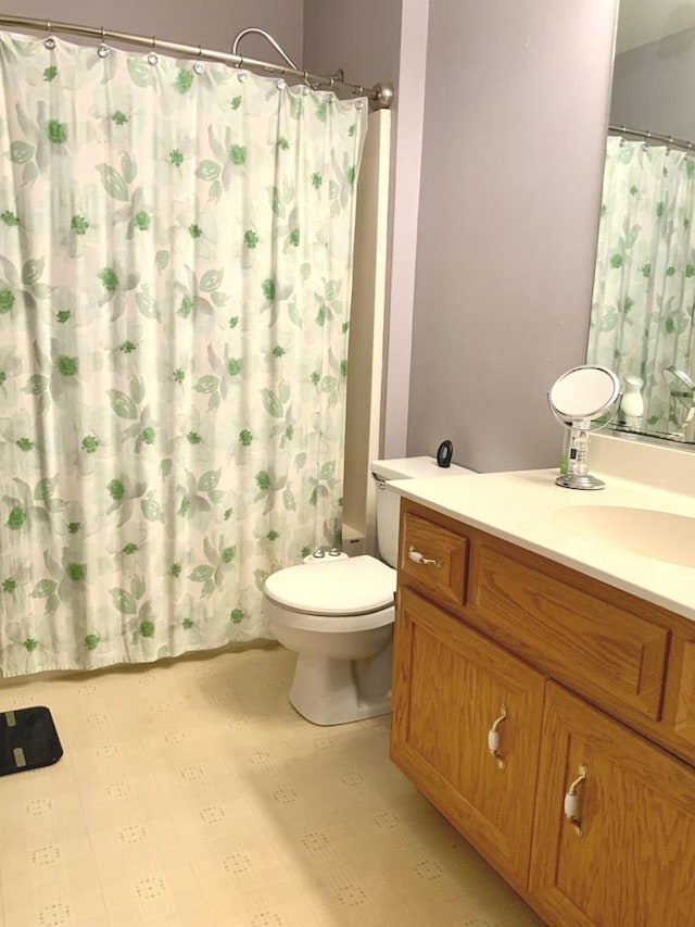 bathroom with toilet, vanity, and curtained shower