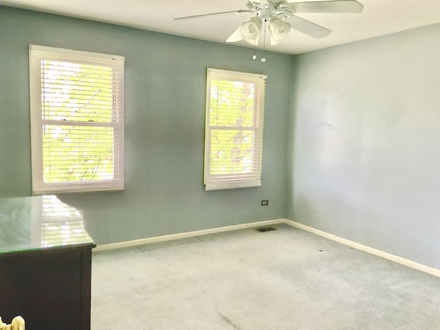 unfurnished room with baseboards, carpet floors, and a ceiling fan