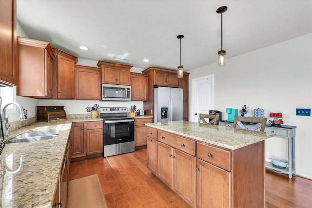 31 Lodge Trl, Monticello, IL 61856 - kitchen featuring stainless steel appliances, a sink, a kitchen island, light wood-style flooring, and brown cabinetry