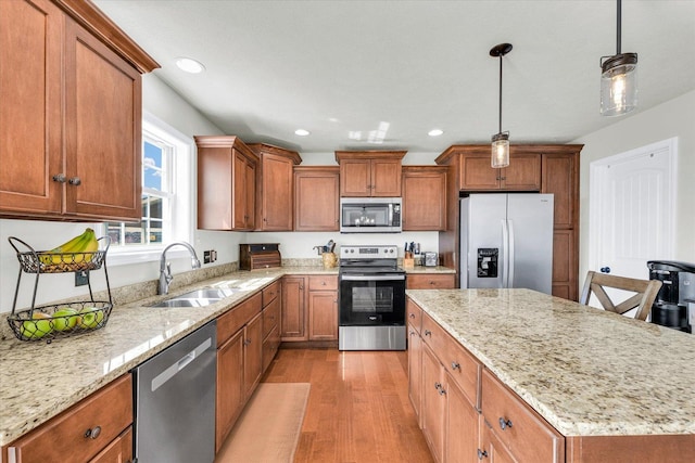 31 Lodge Trl, Monticello, IL 61856 - kitchen with stainless steel appliances, a sink, light wood-style floors, a kitchen island, and brown cabinets