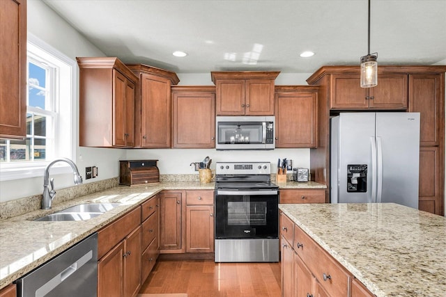 31 Lodge Trl, Monticello, IL 61856 - kitchen featuring stainless steel appliances, a sink, brown cabinets, light stone counters, and light wood-style flooring