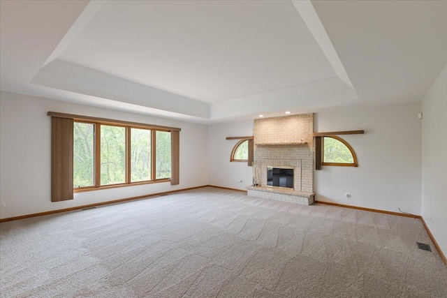 2261 E Gaisor Dr, Crete, IL 60417 - unfurnished living room with a tray ceiling, carpet floors, baseboards, and a brick fireplace