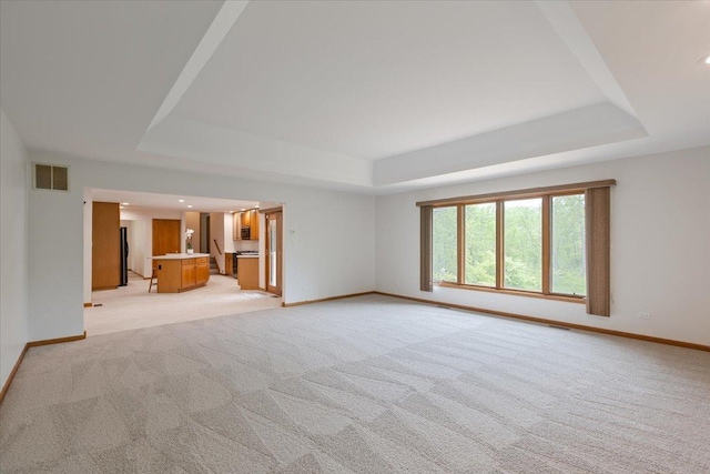 2261 E Gaisor Dr, Crete, IL 60417 - unfurnished living room featuring a tray ceiling, light colored carpet, and baseboards